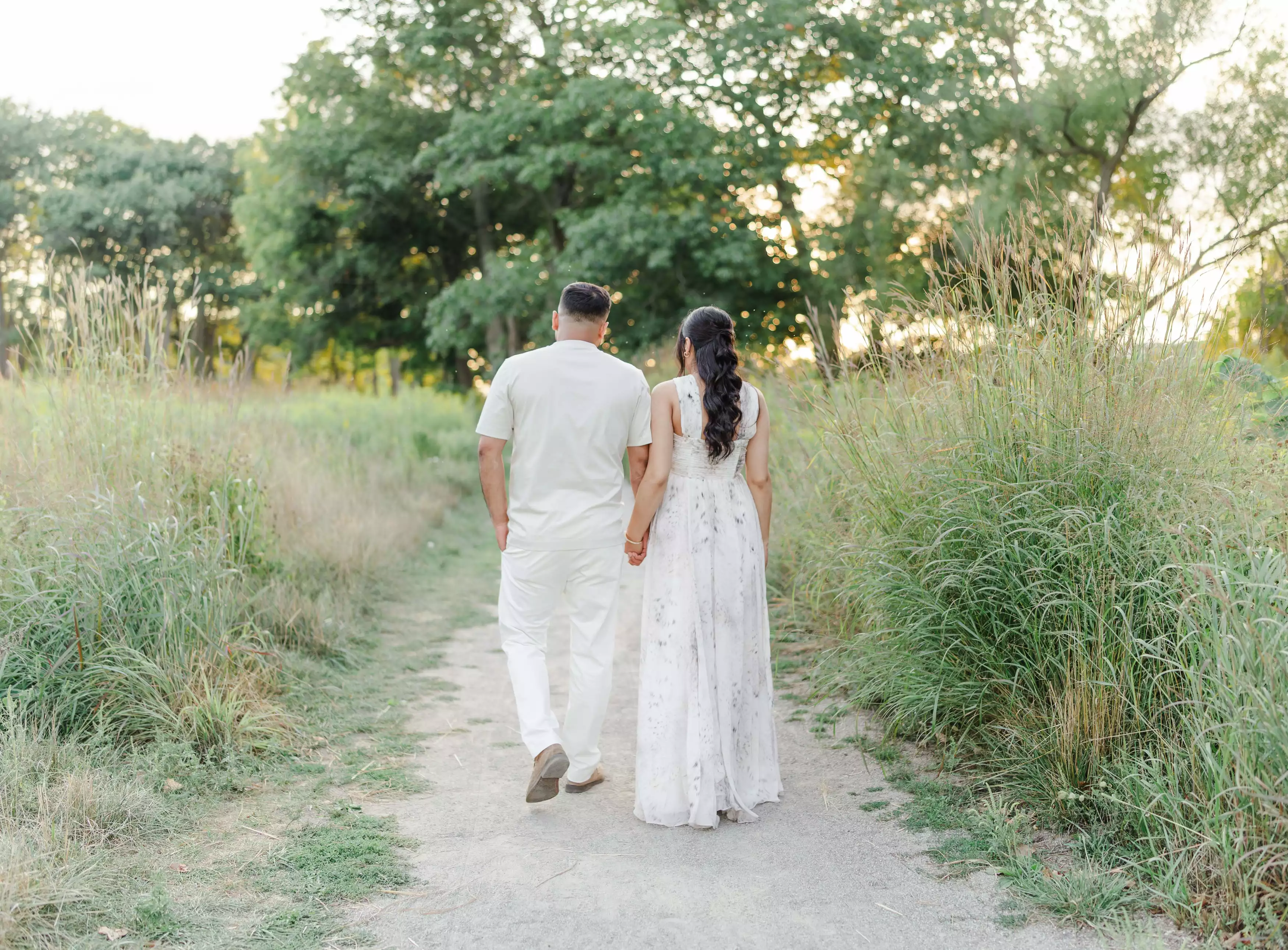 Couple walking hand in hand through a during a Maternity session at Princess Point in Hamilton Ontario.