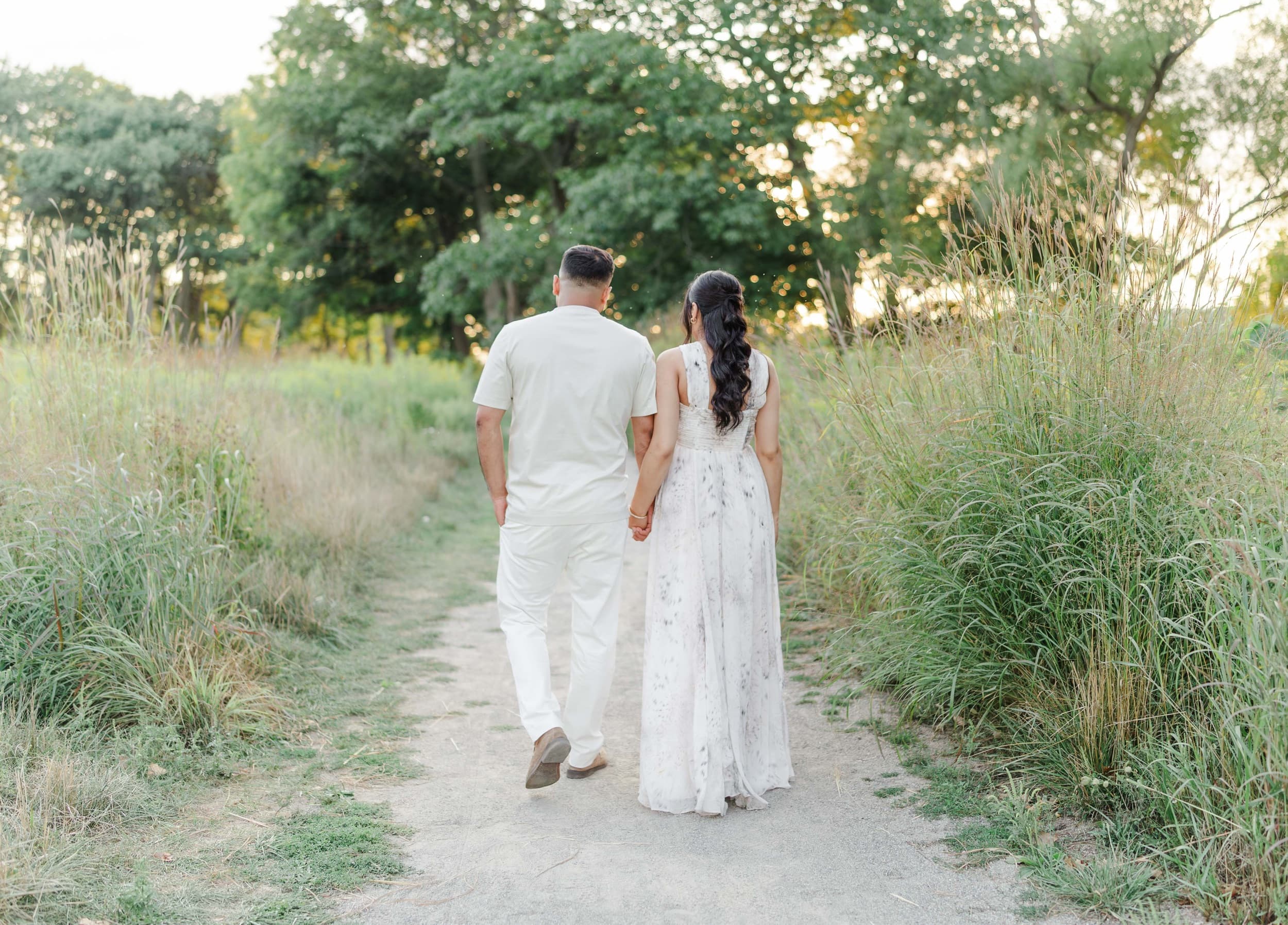 Couple walking hand in hand through a during a Maternity session at Princess Point in Hamilton Ontario.